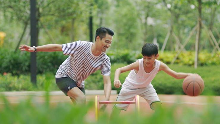 father and son playing basketball outdoors